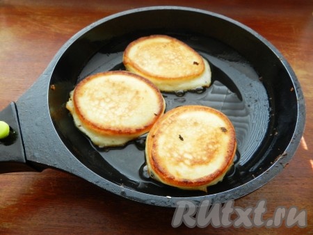 В сковороде разогреть растительное масло и обжарить оладьи из творога с двух сторон.