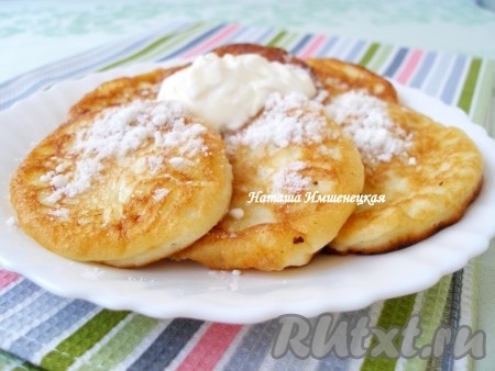 Готовые оладьи посыпать сахарной пудрой и подавать горячими со сметаной.