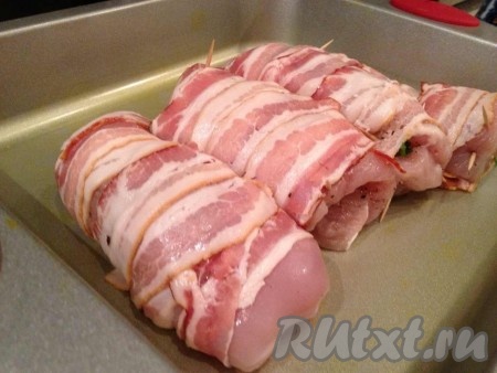 Затем заворачиваем филе в плотные рулетики, оборачиваем беконом и закремляем зубочистками.
