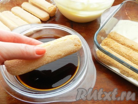 Кофе остудить, влить ликер. На дно формы выложить слой крема. Бисквитное печенье смочить в кофе с двух сторон.