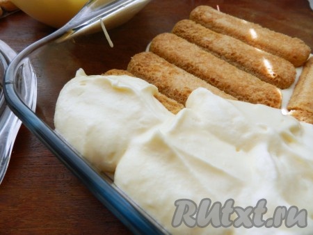 Поверх печенья выложить слой крема. Затем еще один слой печенья, смоченного в кофе, и еще один слой крема.