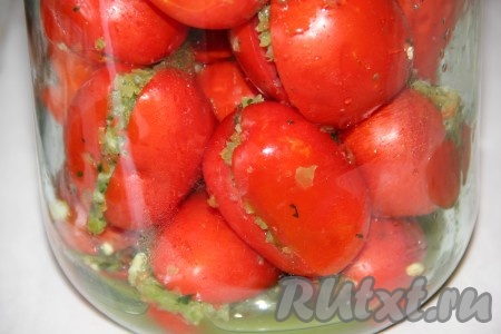 Помидоры моем и разрезаем пополам, не доходя до конца. В разрез выкладываем нашу начинку. Фаршированные помидоры плотно утрамбовываем в простерилизованную банку.