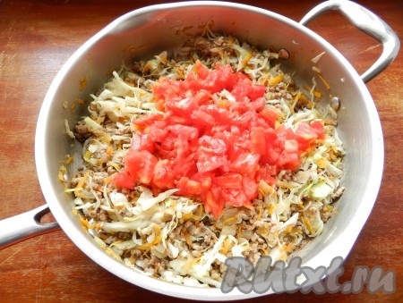 Добавить помидоры, очищенные от кожуры и нарезанные кубиками. Все перемешать и тушить на медленном огне 15-20 минут, до готовности мяса и капусты.