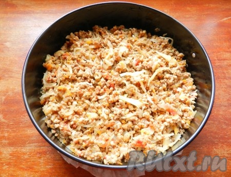 Форму для выпечки застелить бумагой и смазать растительным маслом. Выложить 2/3 теста на дно формы, разровнять. Поверх слоя теста равномерно разложить начинку.