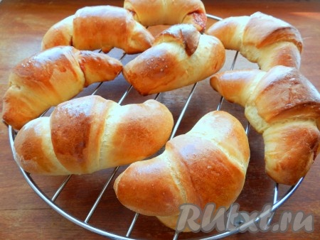 Готовые рогалики из дрожжевого теста переложить на решетку и остудить.