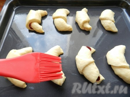 Разложить рогалики на смазанный растительным маслом противень, смазать взбитым яйцом и оставить на 20 минут для подхода.