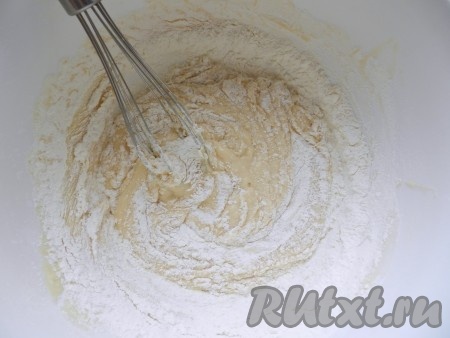 Постепенно добавить муку с дрожжами в смесь ряженки и яиц.