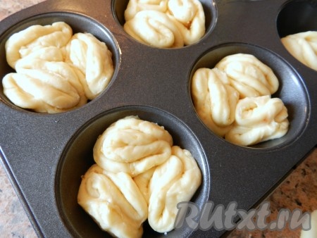 Форму для выпечки смазать растительным маслом.  Укладывать свернутые кружки теста в каждую формочку по три штучки.