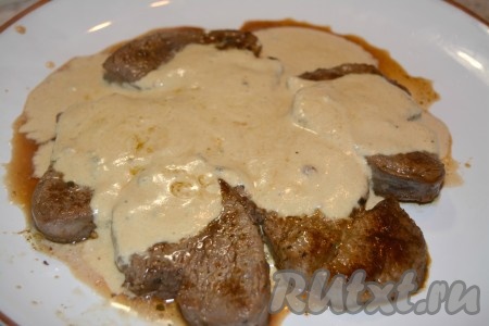 Готовым соусом из сливок залить кусочки говядины на тарелке.
