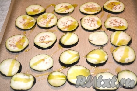 Противень застелить бумагой для выпечки, разложить кружочки баклажанов, слегка сбрызнуть их оливковым маслом.