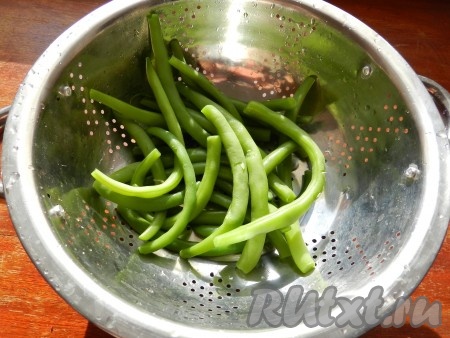 Стручковую фасоль опустить в кипящую подсоленную воду и варить с момента закипания на небольшом огне 7 минут (фасоль должна стать достаточно мягкой, но при этом развариться она не должна). Затем воду слить, фасоль обдать холодной водой.