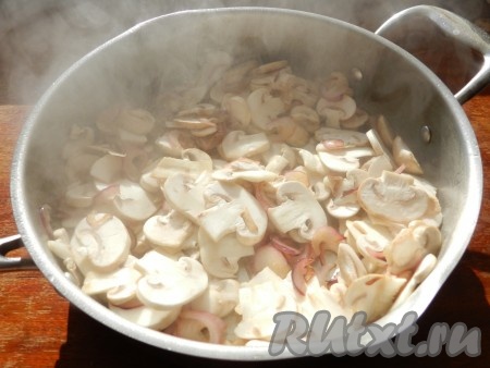 В сковороде разогреть растительное масло, выложить лук и обжарить его до золотистого цвета на среднем огне, помешивая. Затем выложить шампиньоны, перемешать и обжаривать их минут 7, периодически перемешивая.