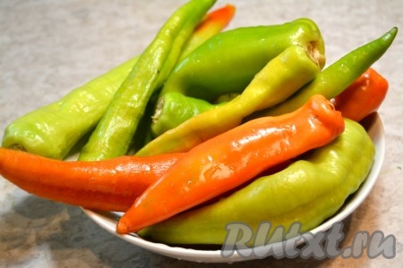 Мясистый острый перец желательно подержать несколько дней при комнатной температуре (разложив на столе), дав ему немного подвянуть, тогда он легче будет утрамбовываться в банки, а на вкусе это никак не отразится. Перец помыть, обсушить и хвостики отрезать.