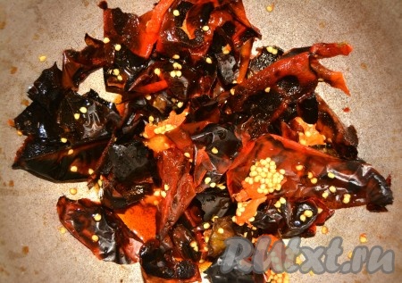 Затем открыть кастрюлю, достать перцы (они уже остынут и будут холодными) и очистить их от черной обуглившейся кожицы.