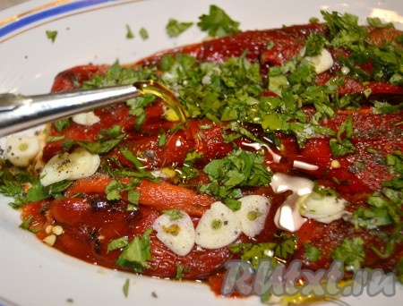 Выложенные перцы посолить, поперчить, полить лимонным соком, оливковым маслом, посыпать тонко нарезанным чесноком и порезанной зеленью.