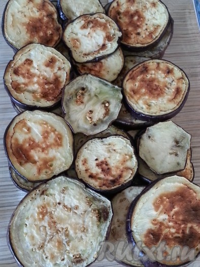 На сковороде с толстым дном обжарить БЕЗ масла с двух сторон баклажаны, предварительно нарезанные на кружочки по 0,5 см (при необходимости, чтобы они не горчили, подержать их перед жаркой в подсоленной воде 20 минут). Выложить баклажаны на дно термопосуды в 2 слоя.
