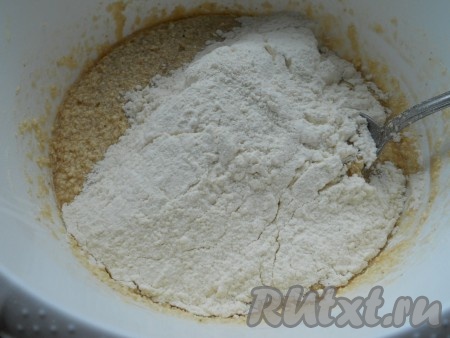 Всыпать разрыхлитель, начать всыпать частями просеянную муку, замешивая песочное тесто.