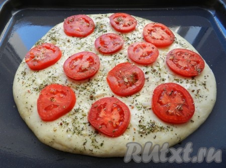 Подошедшее тесто смазать растительным маслом. В принципе, на этом этапе хлеб можно уже отправлять в разогретую духовку. Но я решила поверх теста выложить кружочки помидоров, слегка вдавливая их в тесто, и сверху посыпать заготовку хлебушка итальянскими травами и солью.