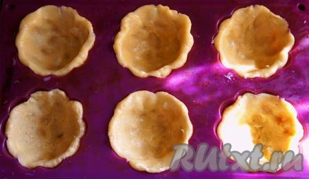 Тесто разделить на 10 равных частей. Формочки (у меня - силиконовые) смазать небольшим количеством растительного масла, выложить тесто, придав ему форму корзиночек. Вилкой наколоть дно корзиночек, чтобы тесто сильно не поднялось при выпечке. Выпекать песочные корзиночки 30 минут в разогрето духовке при температуре 180 градусов. Корзиночки должны стать золотистыми.