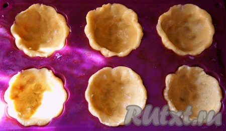 Разделите тесто на 10 равных частей. Формочки для кексов смажьте растительным маслом и распределите тесто по всей площади формочек, сформировав корзиночки. Я выпекала в силиконовых формочках.