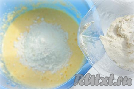 Всыпьте разрыхлитель и небольшими порциями подсыпайте в тесто просеянную муку, перемешивая тесто.
