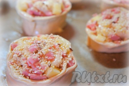 Булочки смазать взбитым яйцом и посыпать семенами льна и кунжутом.