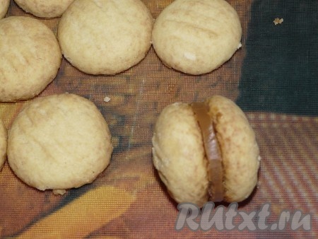 Песочное печенье достать из духовки, остудить. Соединить печенюшки попарно между содой с помощью варёной сгущёнки.