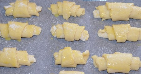 Выложите печенье на противень, застеленный пергаментом, смажьте яйцом и присыпьте сверху сахаром. Поставьте противень с рогаликами в разогретую до 200 градусов духовку на 15-20 минут.