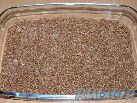 Выложить гречу на дно жаропрочной формы, разровнять. Приготовить 1,5 стакана воды, добавить соль, размешать. Влить подсоленную воду в гречу.