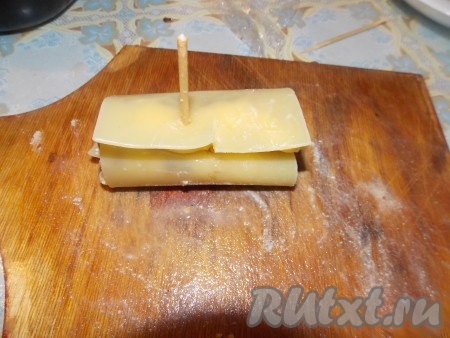 Заворачиваем рулеты из листов лазаньи и закрепляем зубочистками. У меня зубочистки закончились, я поломала пополам шпажки и закрепляла ими. Затем перекладывала рулетики в форму для запекания.
