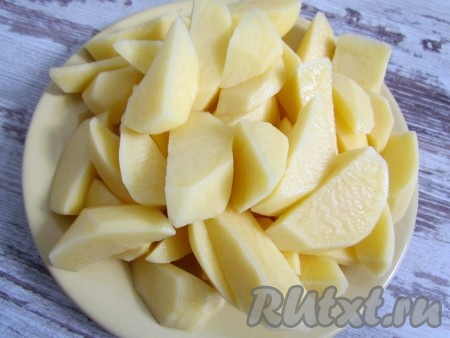 Картофель очистите от кожуры, вымойте и разрежьте вдоль на 4-6 частей.