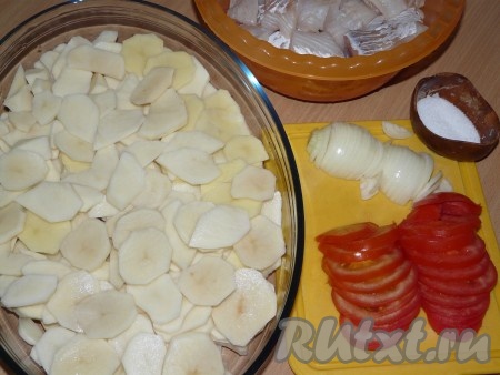  Картофель нарезать тонкими кружочками. Лук почистить и нарезать полукольцами. Помидоры нарезать кольцами или полукольцами. Рыбу нарезать небольшими кусочками. В жаропрочную форму выложить слой картофеля и немного посолить.