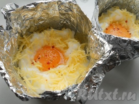 В углубления поместить по одному желтку. Посолить и поперчить по вкусу.