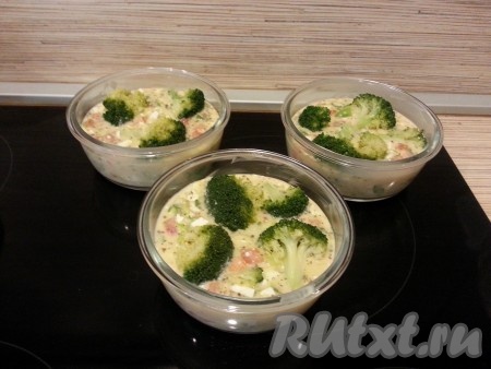 Смазать наши формочки сливочным маслом и в каждую добавить равное количество творожно-овощной смеси. Выложить сверху брокколи, вдавливая ее в смесь.
