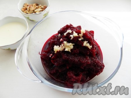 Очищенную свеклу натереть на терке, слить лишний сок. Чеснок пропустить через пресс и добавить к свекле.