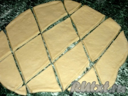 Затем на присыпанной мукой поверхности раскатать тесто в пласт толщиной 3-4 миллиметра и нарезать на ромбы.