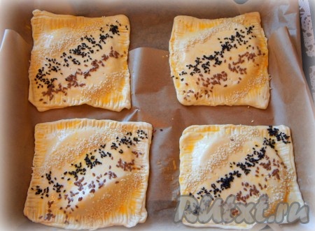 Смажьте слойки взбитым яйцом, посыпьте кунжутом и семенами льна.