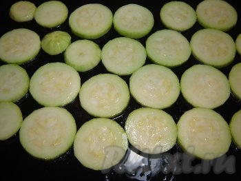 Кабачки очистить от кожуры и нарезать кольцами толщиной 5 мм. Кусочки кабачков посолить. Противень смазать растительным маслом и уложить на него кольца кабачков.