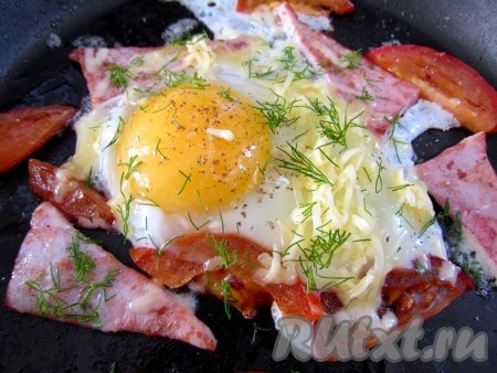 Посолите и поперчите по вкусу. Посыпьте тертым сыром и мелко нарезанной зеленью. Жарьте яичницу до готовности. Можно накрыть на несколько секунд крышкой, тогда яйцо снаружи покроется тонкой белой пленочкой, а внутри останется жидким.