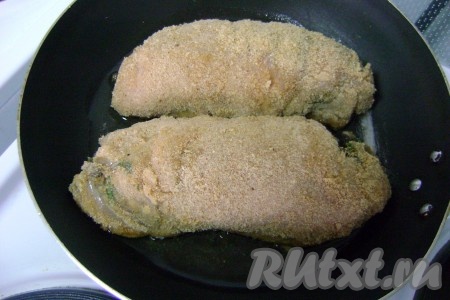 Свернуть филе рулетиком. Также сформировать второй рулетик из второго филе и оставшейся грибной начинки. Яйцо взболтать в миске. Обмакнуть каждый рулетик в яйцо со все сторон, а затем обвалять в сухарях. В сковороде хорошо прогреть растительное масло, выложить куриные рулетики с грибами и жарить их на среднем огне, периодически переворачивая. На обжаривание уйдёт 10-15 минут.