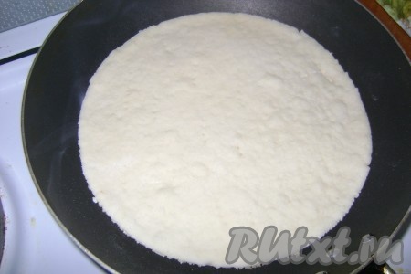 Наколоть корж вилкой, чтобы не вздувался. Печь корж на сухой сковороде с двух сторон до зарумянивания на среднем огне.