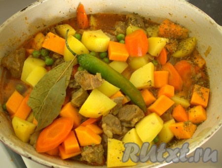 Положила сверху острый перец, лавровый лист, залила горячей водой так, чтобы покрывала овощи на 2/3. Накрыла крышкой и поставила в духовку.