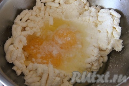 В перекрученный творог добавляем яйца и соду. Хорошенько перемешиваем всю творожную массу.