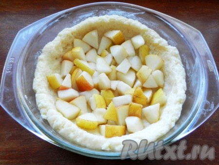 Форму для выпечки смазать маслом. Тесто для пирога распределить по форме, сделав бортики. На творожное тесто выложить кусочки груши.
