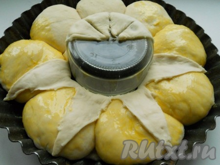 Смазать колобки желтком и каждую разрезанную часть теста выложить сверху.