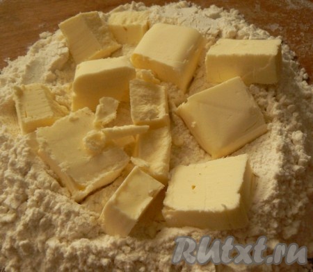 Для начала нам нужно выложить на стол муку, добавить сливочное масло, порубить все ножом до образования крошки.

