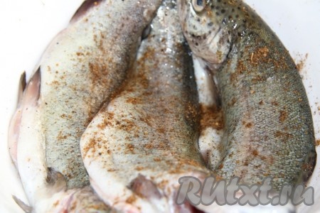 Посолить тушки форели по вкусу, поперчить смесью перцев.