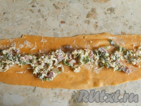 В подготовленные продукты для начинки добавить соль, перец и сметану, перемешать. Каждый отваренный лист теста разрезать на 2 части в длину. Разместить по всей длине начинку.