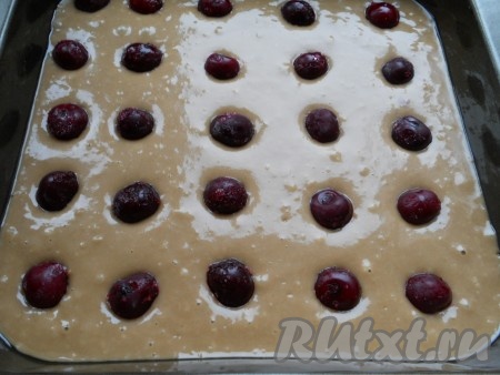 Форму немного смазать маслом и вылить в нее тесто. Сверху разложить вишни.