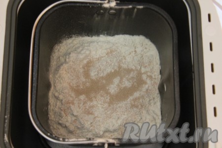 В ведёрко вашей хлебопечки влейте тёплую воду (температура воды должна быть не более 40 градусов) и растительное масло. Добавьте муку, в разные углы ведёрка положите сахар, соль, сухое молоко. Самыми последними положите в середину сухие дрожжи.